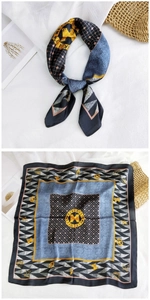 Detail of blue and grey silk scarf featuring geometric patterns and gold Metro City logo