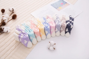 Close-up of colorful coral fleece heart pattern socks arranged on a knit blanket