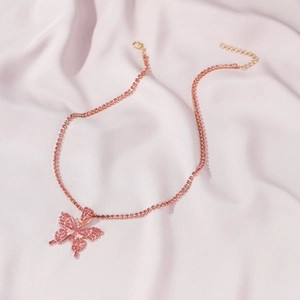 Macro detail of pink rhinestone butterfly pendant on matching tennis chain with silk background