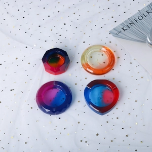 Macro shot of geometric crystal resin ashtrays with vibrant gradient color patterns