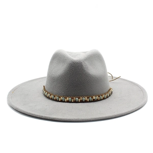 Detail of light grey wide brim fedora hat featuring a bohemian beaded band and string
