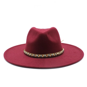 Detail of burgundy wide brim felt fedora hat featuring ethnic beaded band and flat top