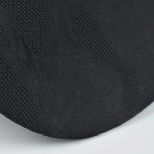 Macro shot of black knitted fabric texture showing dense stitching on a baseball cap