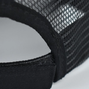 Detailed close-up showing breathable black polyester mesh and stitching on the baseball cap