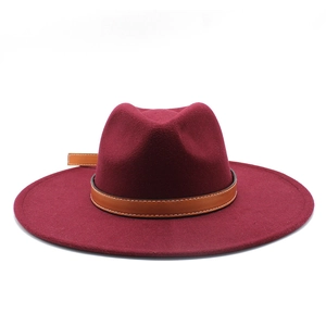 Detail of wine red wide brim fedora hat with brown leather belt buckle strap decoration