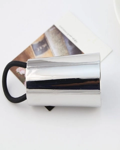 Macro shot of silver metal ponytail cuff with black elastic hair tie on white background