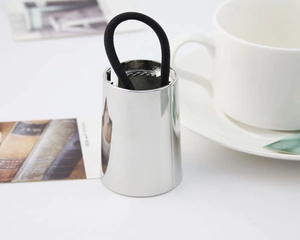 Detail of a polished metallic hair cuff with internal black elastic on a white surface