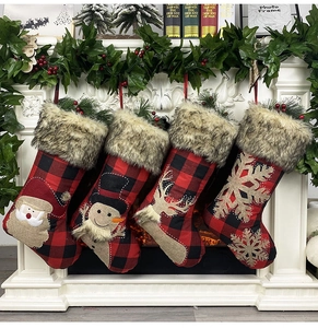 Détail de quatre chaussettes de Noël festives avec bordure en fausse fourrure sur un manteau