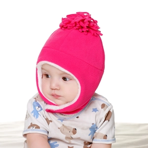 Detail of warm winter baby hat with soft fleece lining and cute pompom in rose pink