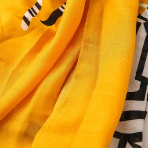 Detailed macro view of yellow cotton linen scarf fabric with black animal print texture