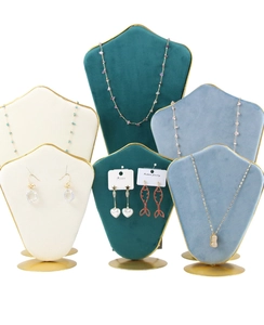Detail of velvet jewelry display stands with gold metal bases and elegant bust design