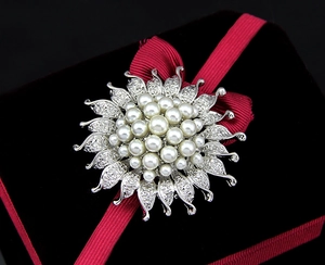 Detailansicht einer silbernen Sonnenblume-Perlenbrosche mit funkelnden Strass-Akzenten