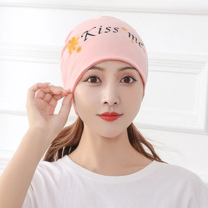 Front view of a pink knitted maternity hat with Kiss Me print on a female model