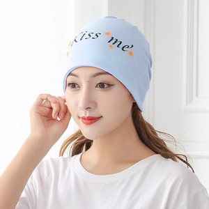 Close-up of light blue maternity beanie with Kiss me print on a female model
