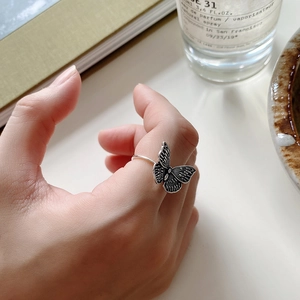 Detailed view of vintage butterfly ring with textured wings and antique silver finish