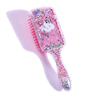 Detail of pink hairbrush filled with glitter, colorful beads, and cute panda patterns
