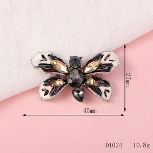 Detail of a butterfly charm with white enamel and rhinestones, size 45mm x 27mm