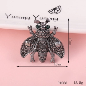 Detail of bee alloy accessory with green gemstone eyes and rhinestones, 40mm x 42mm size