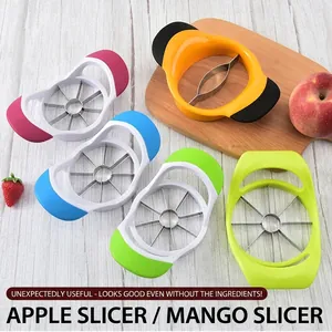 Five assorted stainless steel apple and mango slicers on a rustic wooden tabletop