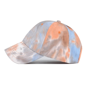 Detail view of cotton tie-dye baseball cap in orange and light blue with a curved brim