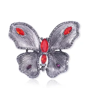 Vintage silver butterfly brooch with elegant red gemstones and purple rhinestone accents