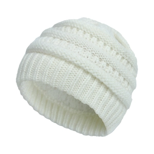 Macro view of white thick knitted winter beanie featuring warm ribbed texture and soft wool