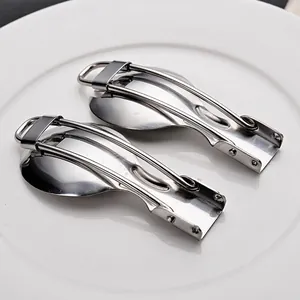 Portable stainless steel folding fork and spoon set on white ceramic plate for outdoors