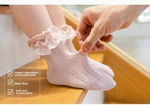 Detail of pink cotton mesh socks with delicate lace trim on a warm wooden background