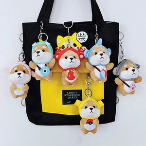 Detail of six colorful Shiba Inu plush keychains hanging on a canvas tote bag
