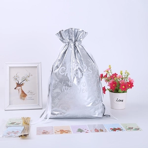 Silver foil Christmas drawstring gift bag with snowflake snowman prints and tags