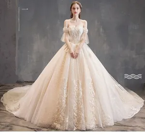 Detail of champagne bridal gown with lace embroidery, detachable sleeves and long train