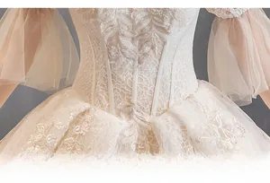 Detail of champagne bridal gown with lace embroidery and structured corset waist