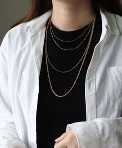 Detailed view of 45cm to 70cm gold titanium steel necklaces on a model's neck
