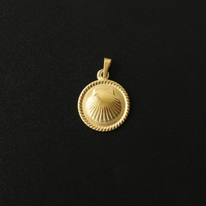 Macro detail of 18K gold plated seashell pendant with braided texture and ring