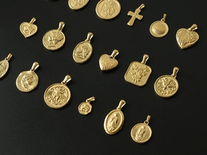 Macro shot of 18K gold plated titanium steel charms with diverse vintage relief patterns