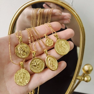 Detailed view of layered 18K gold plated titanium necklaces with vintage coin pendants