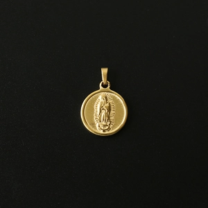 Macro shot of 18K gold-plated retro coin pendant with a religious figure embossed design