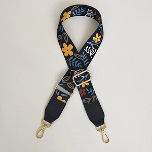 Floral embroidered wide shoulder strap with golden metal clasps and leather ends