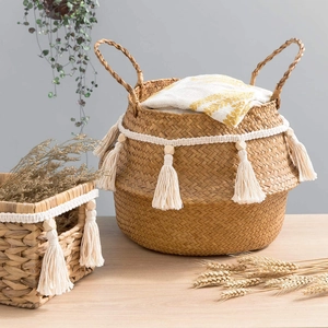 Boho seagrass storage baskets with cotton tassels and beads on a wooden tabletop