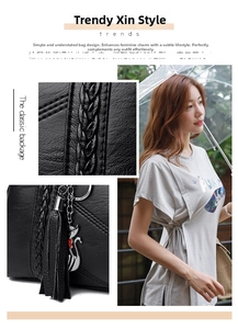Detail of black leather tote bag featuring woven texture and cat tassel charm