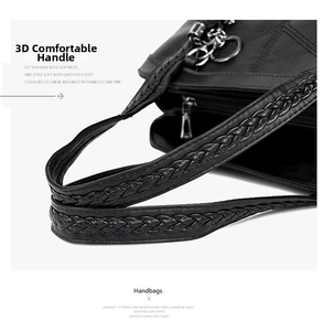 Detail of woven double handles and quilted texture on a black faux leather tote bag
