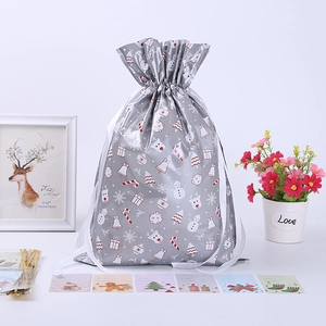 Sachets cadeaux de Noël argentés avec motifs, attaches dorées et cartes de vœux festives