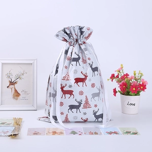 Christmas drawstring gift bags with reindeer and tree patterns including tags and ties