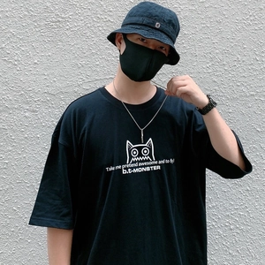 Close-up of black cotton T-shirt featuring cartoon monster print and typography on chest