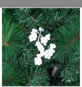 Close-up of white foam berry clusters for DIY Christmas tree decoration on green pine needles