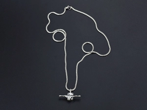 Detailed macro view of silver titanium steel necklace featuring a skateboard truck pendant