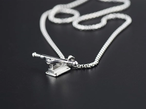 Macro shot highlighting the metallic texture of the silver skateboard truck pendant