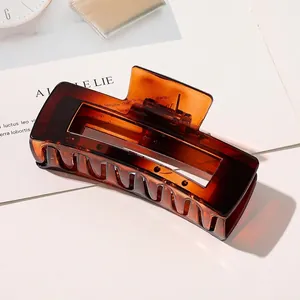 Macro shot of large amber rectangular hair claw clip with semi-transparent resin texture