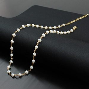 Detail of egg-shaped freshwater pearl necklace with gold wire wrapping and lobster clasp