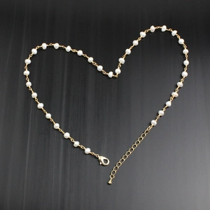 Detail of elegant gold-plated necklace with fresh water pearls in heart layout